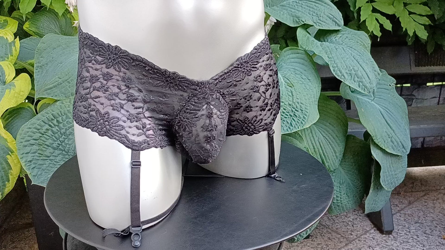 Herren Strapse aus schwarzer elastischer Spitze. Der Tanzgürtel ist ouvert mit Push-Up Suspensorium und Cockring